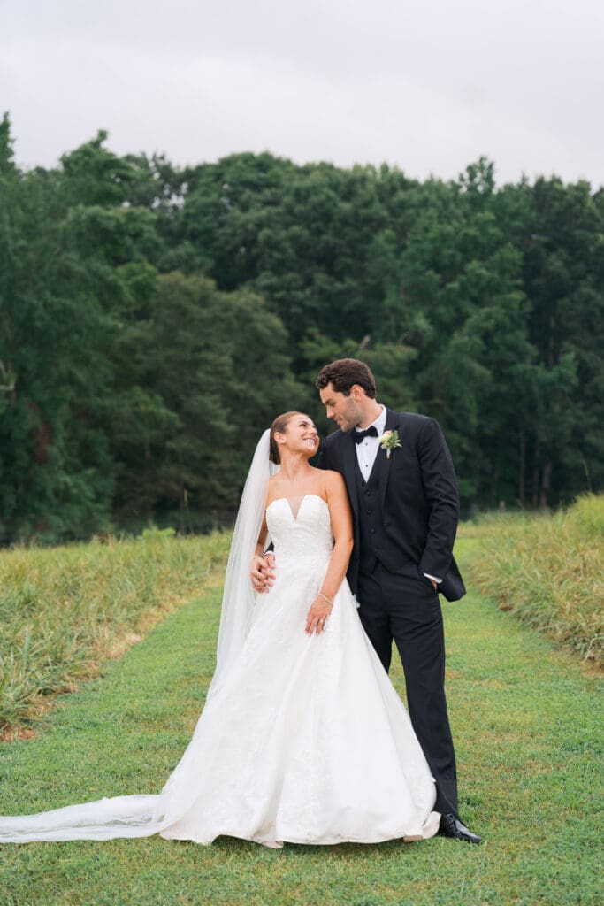 A couple embracing as newlyweds in a field