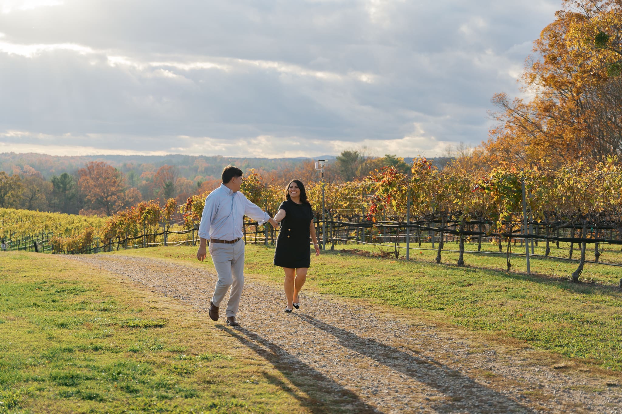 a couple running through the vineyards at montaluce winery during sunset