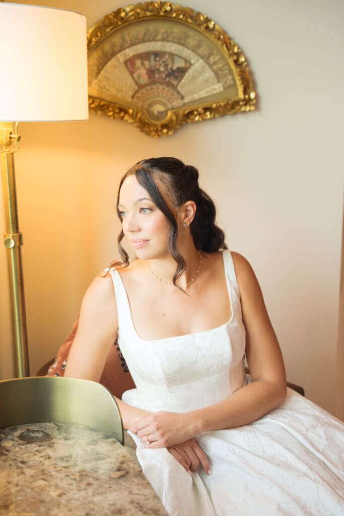 a bride looking out the window while sitting in a chair